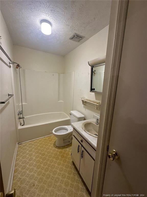 full bathroom with vanity, a textured ceiling, shower / bath combination, and toilet