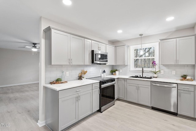 kitchen featuring decorative backsplash, sink, stainless steel appliances, and light hardwood / wood-style floors