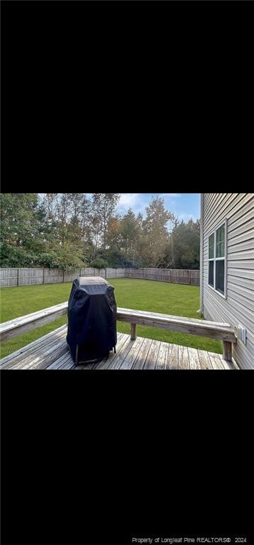 wooden deck with a grill and a yard