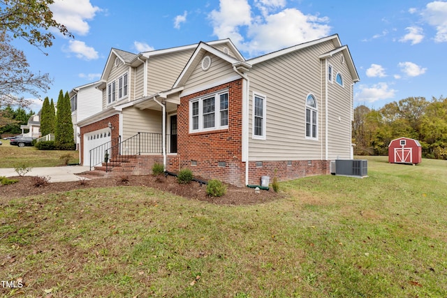 view of front of house featuring a storage unit, cooling unit, a garage, and a front yard