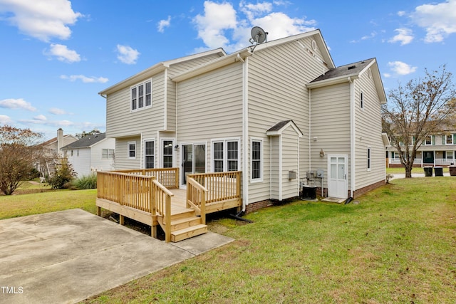 rear view of property with a lawn, a wooden deck, a patio area, and central AC