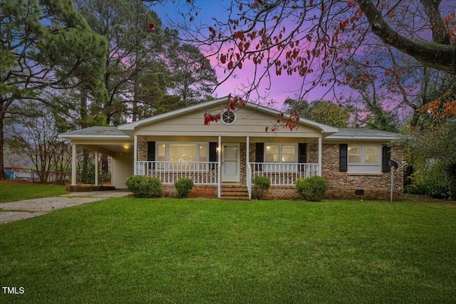 single story home with covered porch, a carport, and a lawn