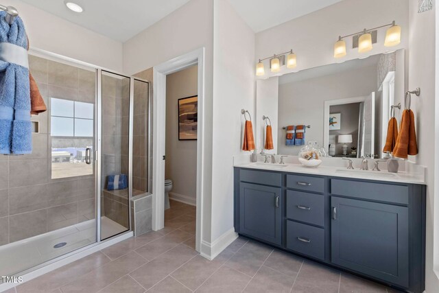 bathroom with tile patterned flooring, vanity, toilet, and walk in shower