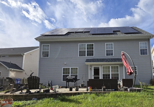 rear view of property with solar panels and a deck