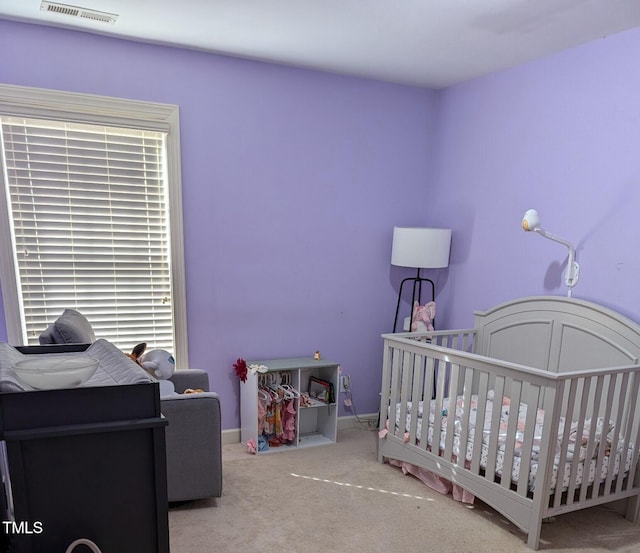 carpeted bedroom featuring a nursery area