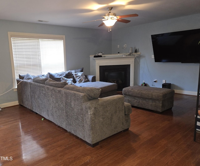 living room with ceiling fan and dark hardwood / wood-style flooring