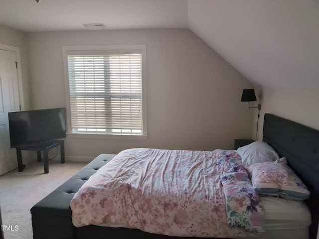 carpeted bedroom with lofted ceiling