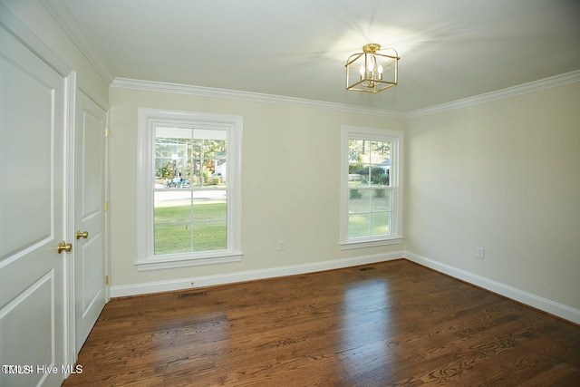 empty room featuring ornamental molding, dark hardwood / wood-style floors, and an inviting chandelier