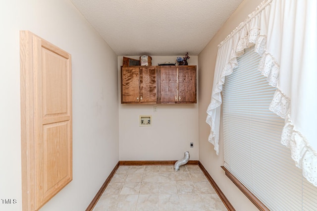 washroom with hookup for a washing machine, cabinets, a textured ceiling, and hookup for an electric dryer