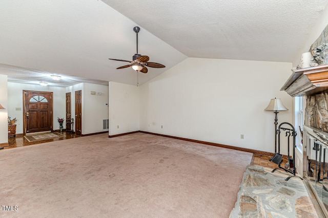 unfurnished living room with a textured ceiling, ceiling fan, carpet floors, and lofted ceiling