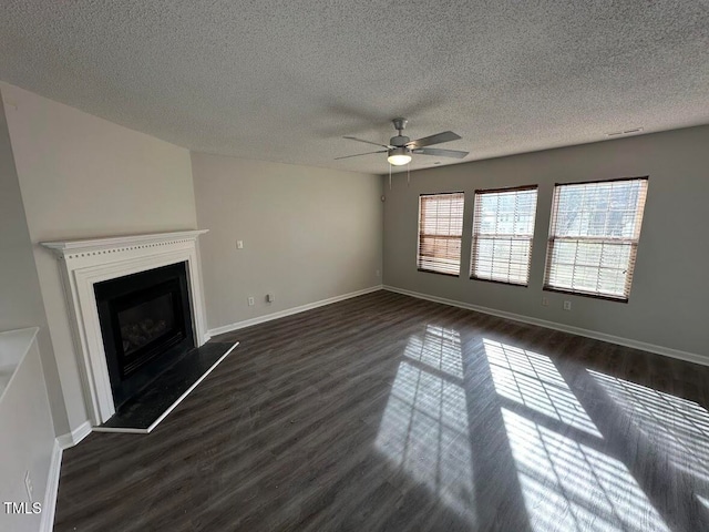 unfurnished living room featuring a textured ceiling, ceiling fan, and dark wood-type flooring