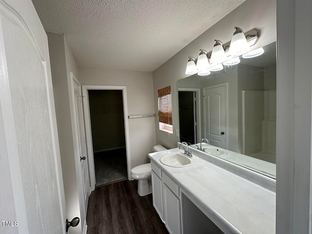 bathroom with hardwood / wood-style floors, vanity, a textured ceiling, and toilet