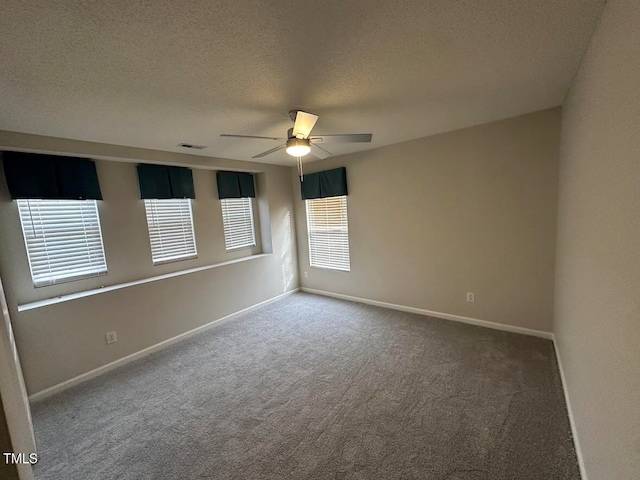 empty room featuring ceiling fan, carpet floors, and a textured ceiling