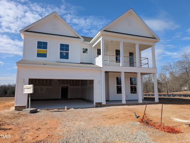 view of front of property with a garage, a balcony, and a porch