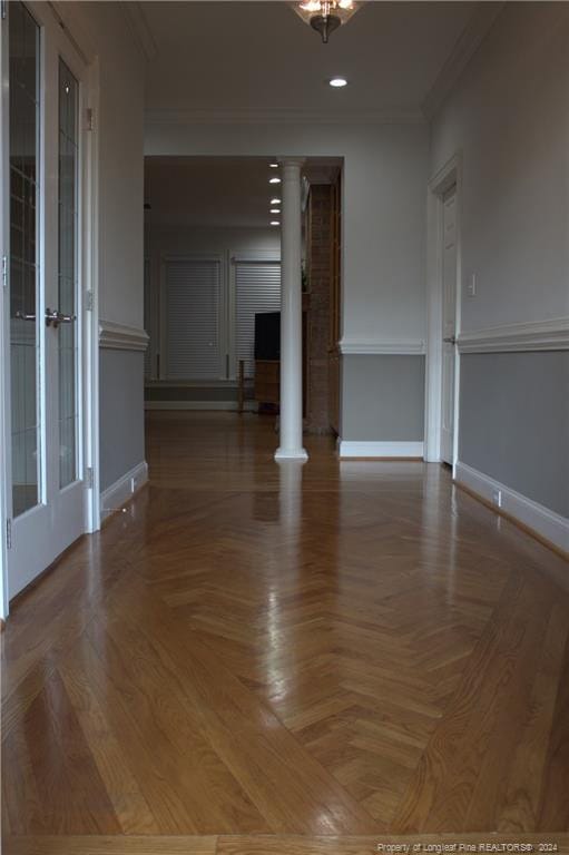 empty room with ornate columns, parquet floors, and crown molding