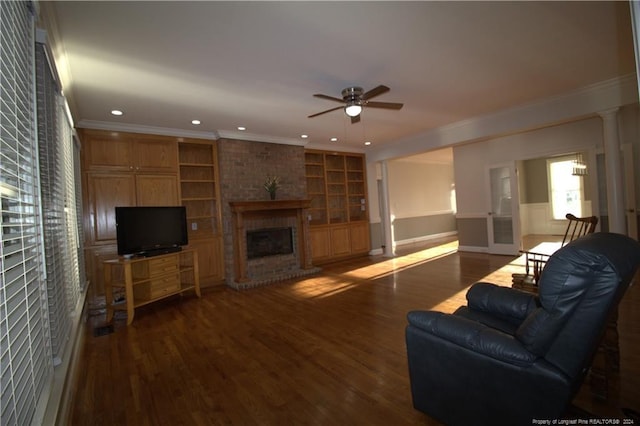 living room with hardwood / wood-style flooring, crown molding, and a brick fireplace