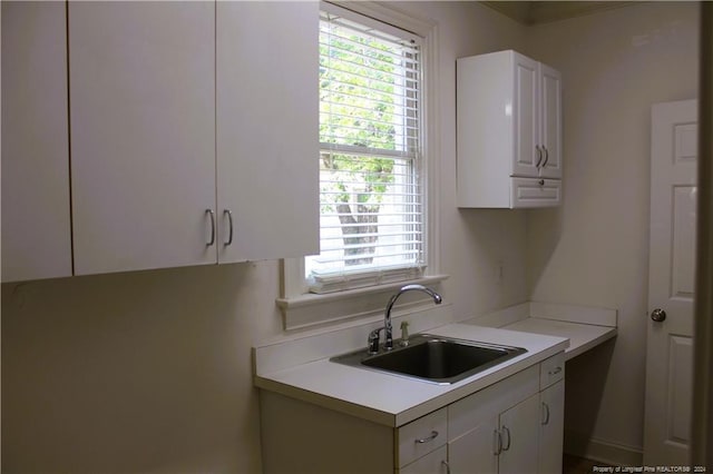 kitchen with white cabinets, a healthy amount of sunlight, and sink