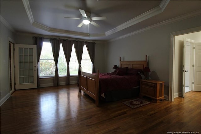 bedroom featuring a tray ceiling, ceiling fan, crown molding, and dark wood-type flooring