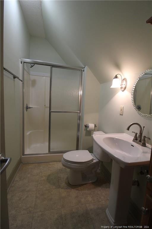 bathroom featuring toilet, tile patterned floors, vaulted ceiling, and a shower with door