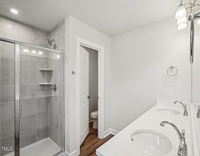 bathroom featuring hardwood / wood-style floors, vanity, toilet, and an enclosed shower