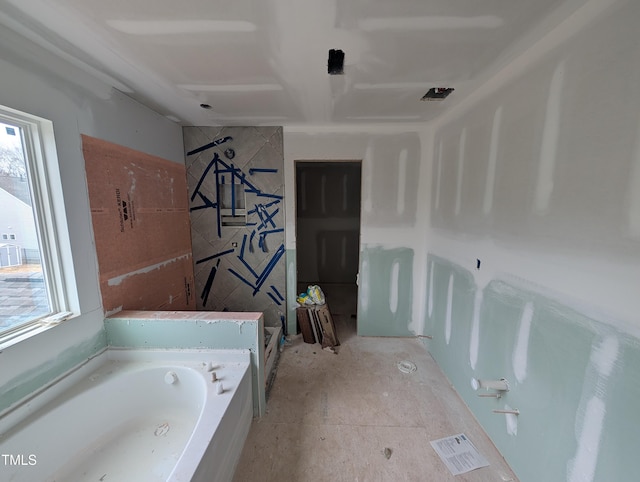 bathroom featuring a bathing tub and a healthy amount of sunlight