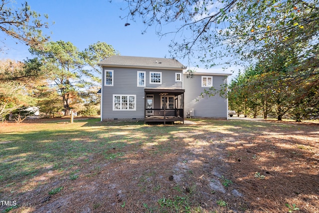 rear view of property with a yard and a wooden deck