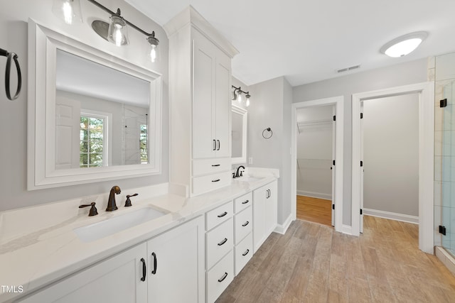 bathroom with vanity, wood-type flooring, and walk in shower