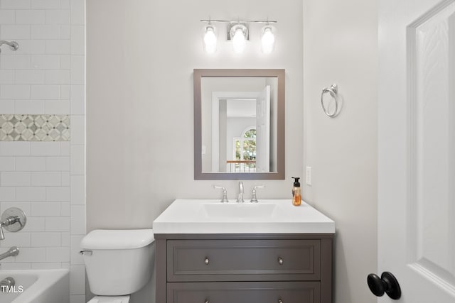 full bathroom featuring tiled shower / bath combo, toilet, and vanity