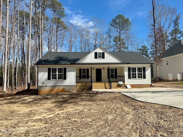 view of front facade with a porch, board and batten siding, and a shingled roof