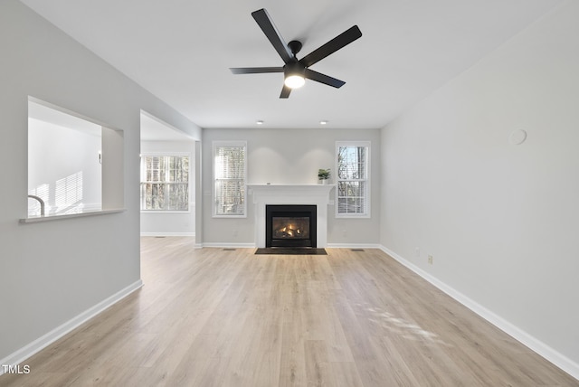 unfurnished living room featuring ceiling fan and light wood-type flooring