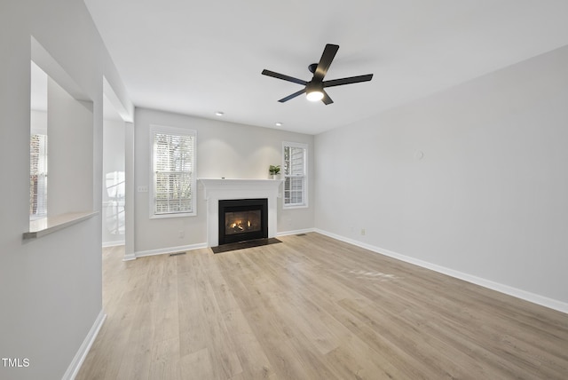 unfurnished living room featuring ceiling fan and light wood-type flooring