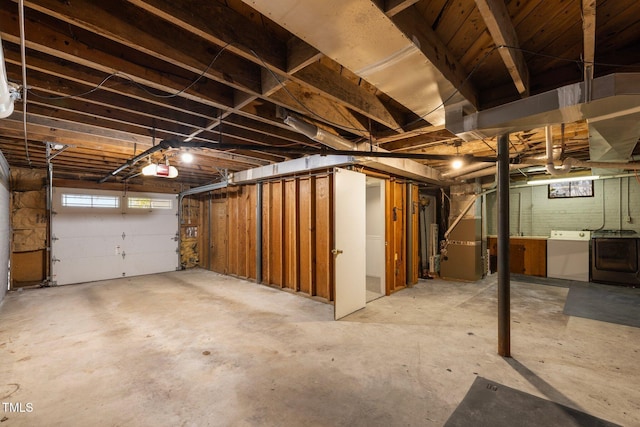 garage featuring heating unit, washer / dryer, and a garage door opener