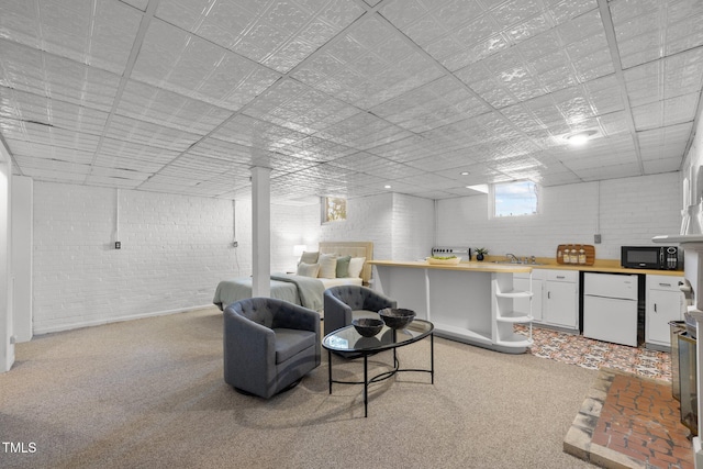 basement featuring fridge, brick wall, and light carpet