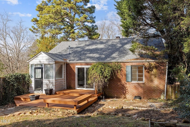 rear view of property featuring a wooden deck and a sunroom