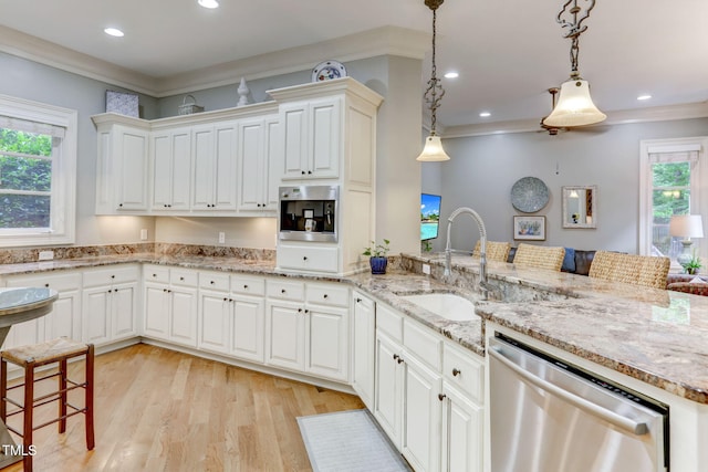 kitchen with light hardwood / wood-style floors, stainless steel dishwasher, sink, decorative light fixtures, and ornamental molding