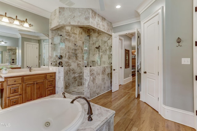 bathroom featuring wood-type flooring, crown molding, separate shower and tub, and vanity