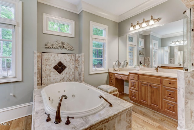 bathroom featuring crown molding, plenty of natural light, tiled tub, and vanity