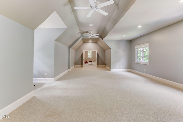 additional living space with ceiling fan, light colored carpet, and lofted ceiling