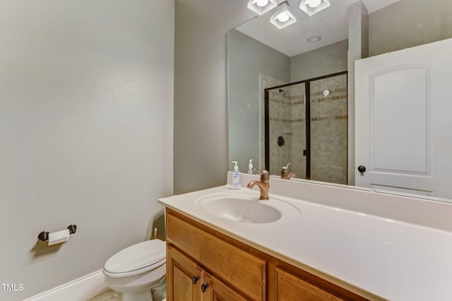 bathroom with toilet, an enclosed shower, and vanity