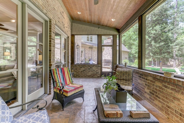 sunroom / solarium with ceiling fan, wooden ceiling, and lofted ceiling