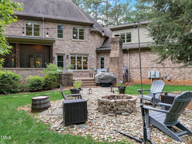 rear view of property featuring a patio area and an outdoor fire pit