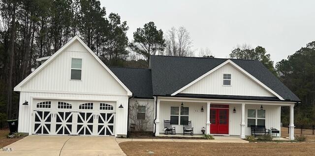 modern farmhouse style home with a porch and a garage