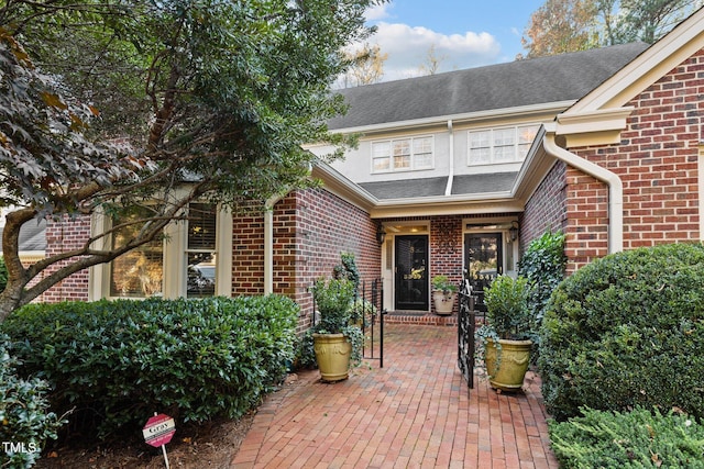 view of exterior entry with a patio