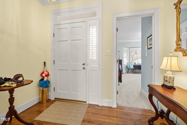 foyer with light hardwood / wood-style flooring and ornamental molding