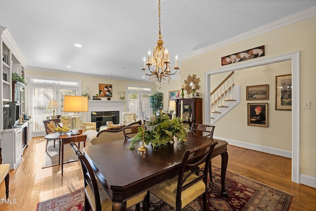 dining area with a healthy amount of sunlight, ornamental molding, and light hardwood / wood-style flooring