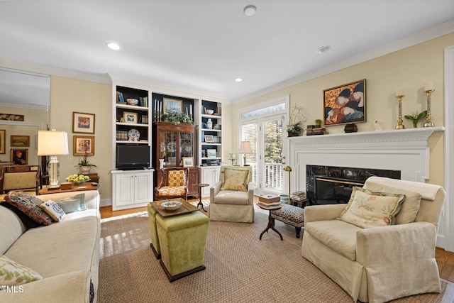 living room with light hardwood / wood-style floors, ornamental molding, and a premium fireplace