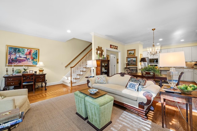 living room featuring crown molding, light hardwood / wood-style flooring, and a notable chandelier