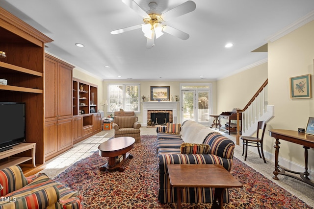 carpeted living room with crown molding, a fireplace, and ceiling fan