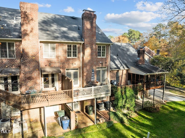 rear view of house featuring a lawn, cooling unit, and a garage