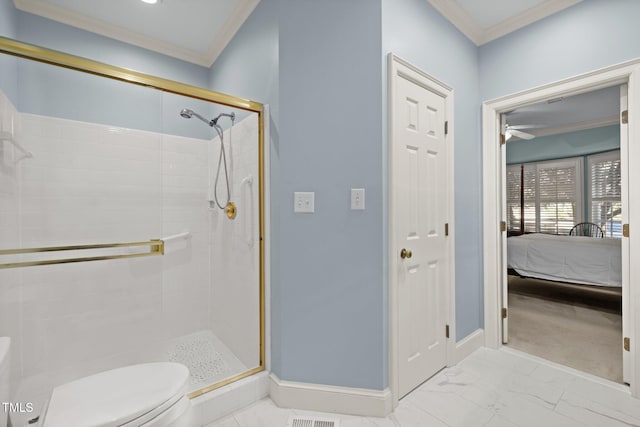 bathroom with toilet, crown molding, and a shower with shower door